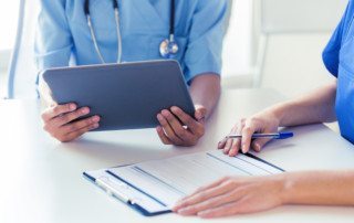 close up of doctors with tablet pc at hospital